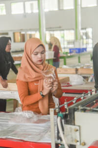 Image of PT Sinergi Handal Interpack Supervisor checking the plastic product for quality control