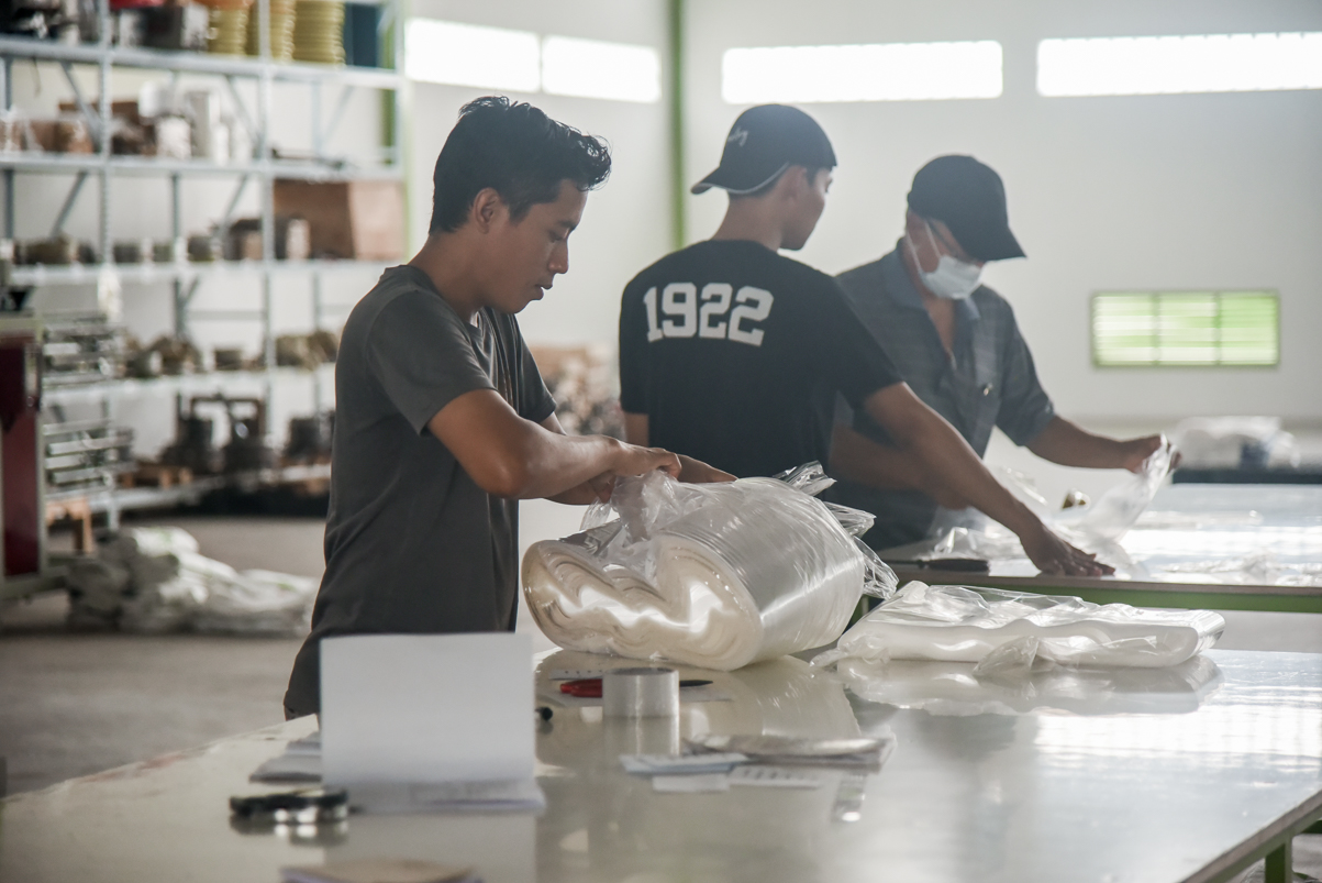 Workers packing and testing plastic polypropylene rolls